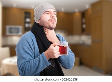 Handsome Man Having A Sore Throat And Drinking Hot Tea At  His Home