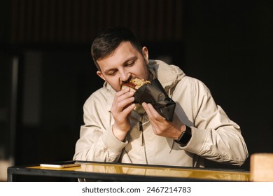 Handsome man having traditional hot dog cuisine during rest break. Caucasian guy enjoying street cuisine outdoor. Male eating unhealthy fast food - Powered by Shutterstock