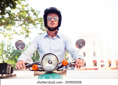 Handsome Man In Helmet Riding On Scooter In Town