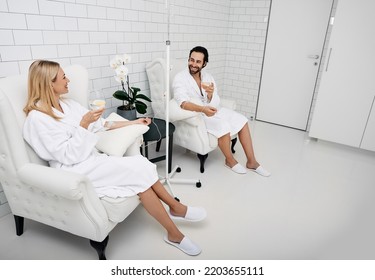 Handsome man with his girlfriend with glasses of refreshing lemon drink in wellness center. Couple while intravenous vitamin therapy. Detox human organism - Shutterstock ID 2203655111