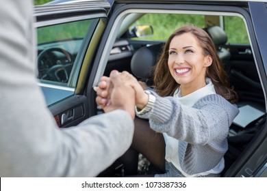 Handsome Man Holding Car Door For Beautiful Businesswoman Daytime