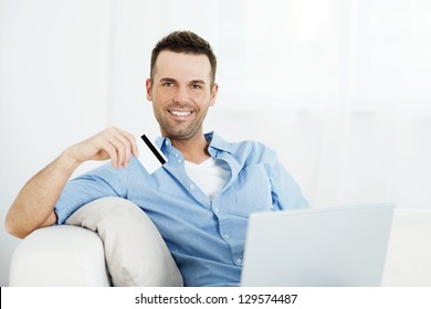 Handsome Man Holding Credit Card And Using Laptop