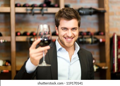 Handsome man holding a glass of wine - Powered by Shutterstock