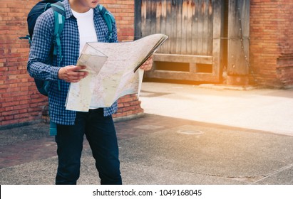 Handsome Man Holding Map Paper With Finding Location For Travel.