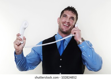 Handsome Man Holding Up Two Phones Connected By A Single Telephone Wire