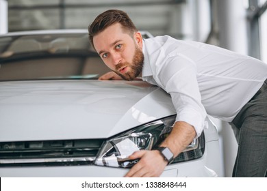 Handsome Man Hugging A Car In A Showroom