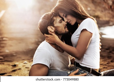 Handsome man hugging his woman on a beach