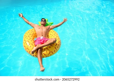 Handsome Man With Inflatable Ring In Swimming Pool