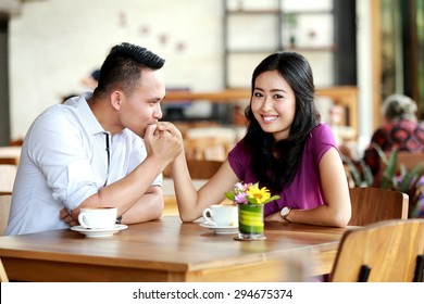handsome man kissing his girlfriend hands during dating at coffee shop