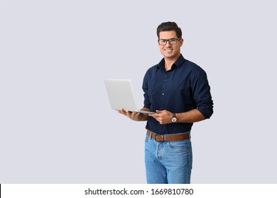 Handsome Man With Laptop On Light Background