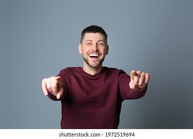 Handsome man laughing on grey background. Funny joke - Shutterstock ID 1972519694