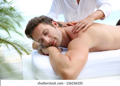 Handsome man laying on a massage bed