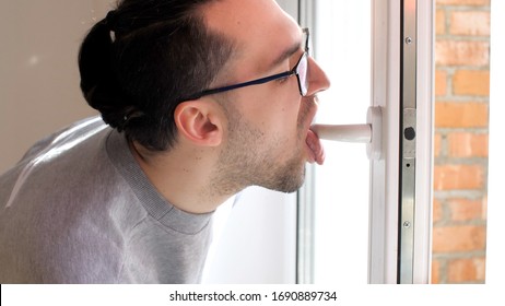 Handsome Man Licks A Doorknob. Covidiot. Coronavirus Or COVID-19. 