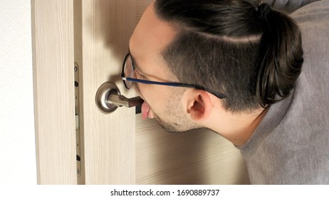 Handsome Man Licks A Doorknob. Covidiot. Coronavirus Or COVID-19. 