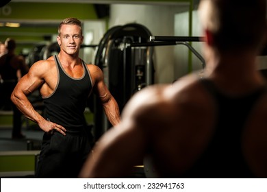 Handsome Man Looking In Mirror After Body Building Workout