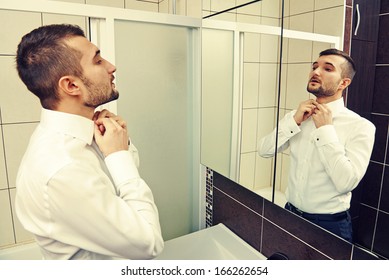 handsome man looking at mirror and get dressed