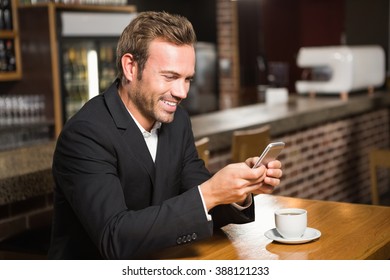 Handsome Man Looking At Smartphone And Having A Coffee In A Pub