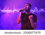 Handsome man with microphone singing in neon lights on color background. Audio waveform near him