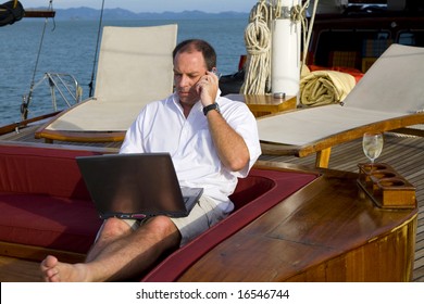 Handsome Man On Deck Of Yacht With Mobile Phone And Laptop