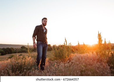 Handsome man on sunset background - Shutterstock ID 672664357