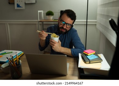 Handsome Man On A Work Call During The Night. Workaholic Man Eating Dinner At His Office 