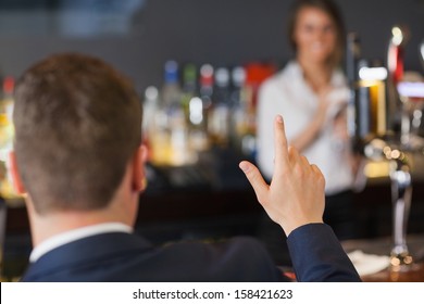 Handsome Man Ordering A Drink From Pretty Waitress In A Classy Bar