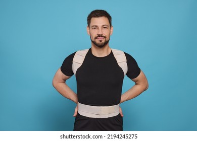 Handsome Man With Orthopedic Corset On Blue Background