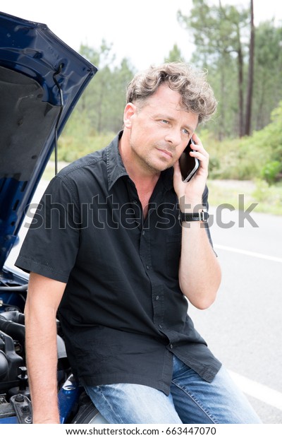 handsome\
man in phone with smartphone and car break\
down