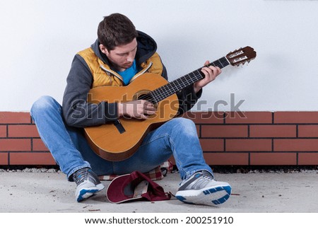 Handsome man playing guitar on the street