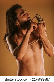 Handsome Man Playing With His Bearded Dragon While Standing At The Studio