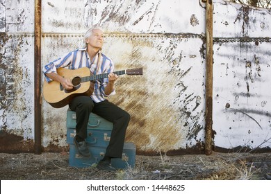 Handsome Man Playing An Old Acoustic Guitar