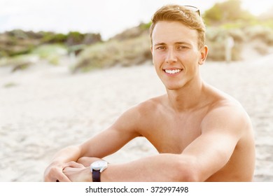 Handsome man posing at beach - Shutterstock ID 372997498