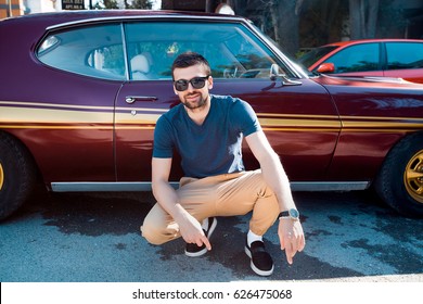 Handsome Man Posing Near Car.guy In Sunglasses Posing In Daylight.Bearded Man,casual Wear,blue Shirt,pretty Face,hipster,attractive,Outdoor Portrait Of Man,stylish Outfit,smiling Man,showing Ok