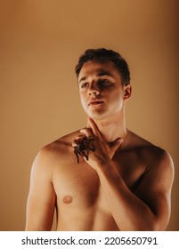 Handsome Man Posing With Tarantula While Standing At The Studio