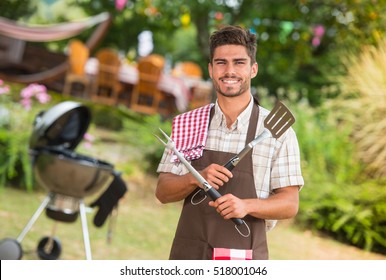 Handsome man preparing barbecue for friends, France