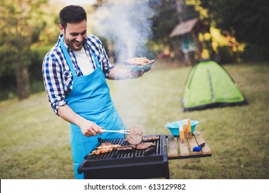 Handsome man preparing barbecue for friends outdoor