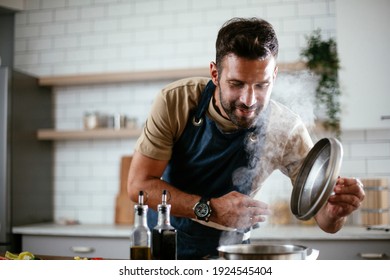 Handsome Man Preparing Pasta In The Kitchen. Guy Cooking A Tasty Meal.