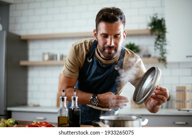 Handsome Man Preparing Pasta In The Kitchen. Guy Cooking A Tasty Meal.	