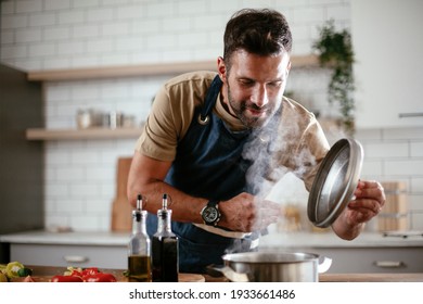 Handsome man preparing pasta in the kitchen. Guy cooking a tasty meal.	