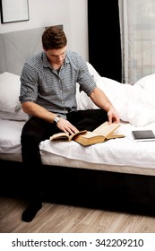 Handsome Man Reading A Book In His Bed.