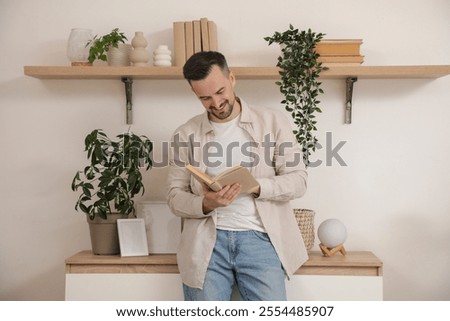 Handsome man reading book near commode at home
