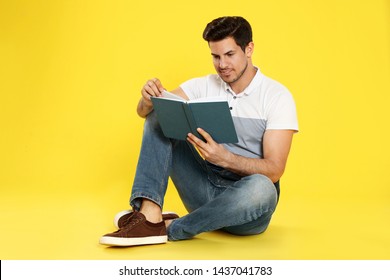 Handsome Man Reading Book On Color Background, Space For Text