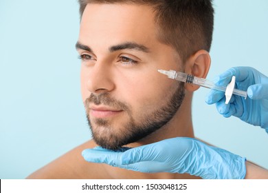 Handsome Man Receiving Filler Injection On Color Background