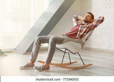 Handsome Man Relaxing In Rocking-chair At Home