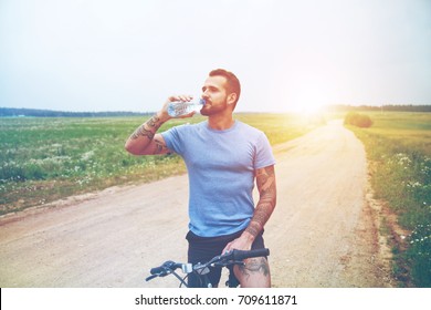 handsome man riding bike and drinking water resting