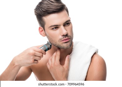 handsome man shaving with electric trimmer isolated on white - Shutterstock ID 709964596