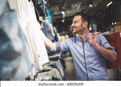 Handsome Man Shopping For New Clothes In Store