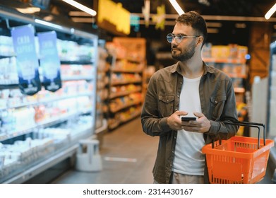 Handsome man shopping in a supermarket. - Powered by Shutterstock