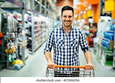 Handsome Man Shopping In Supermarket Pushing Trolley