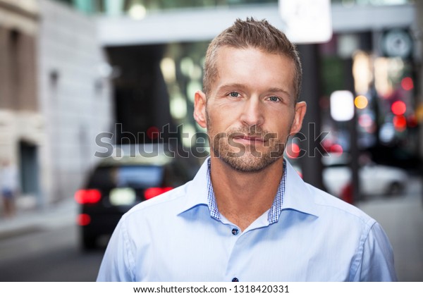 Handsome man with short beard serious on a street.\
He is so calm